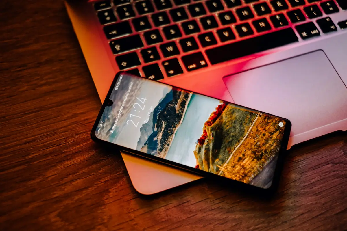 手機與筆電放在桌面上，象徵 iPhone、iPad 與 Mac 檢查官方系統更新