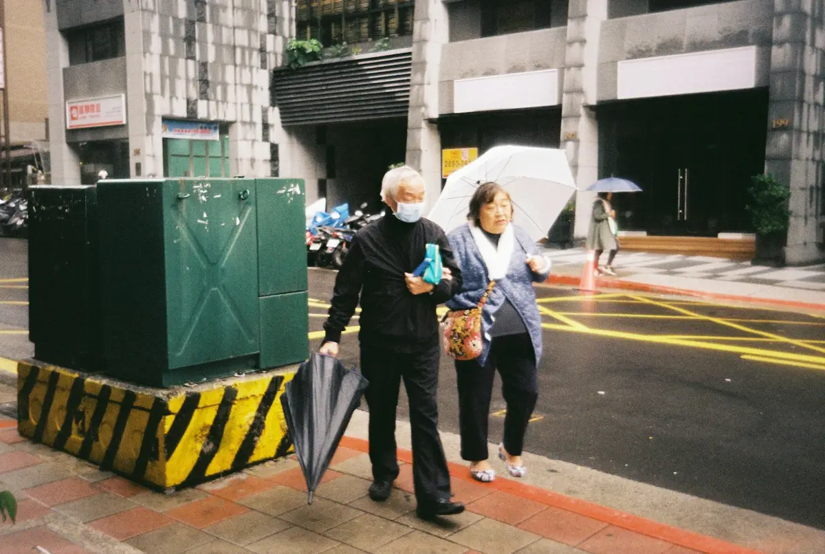 台灣夏季雨天街道上的雨傘與陰雨天空示意圖