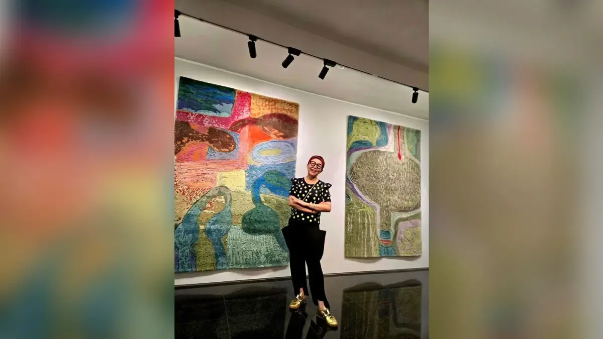 沈佳玲站在大型織品作品前