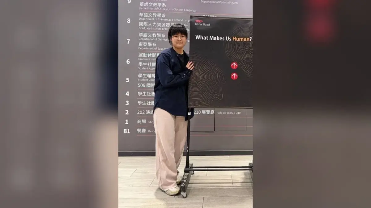 李姿瑩在 TEDxRenaiRoad活動場地與主視覺合影