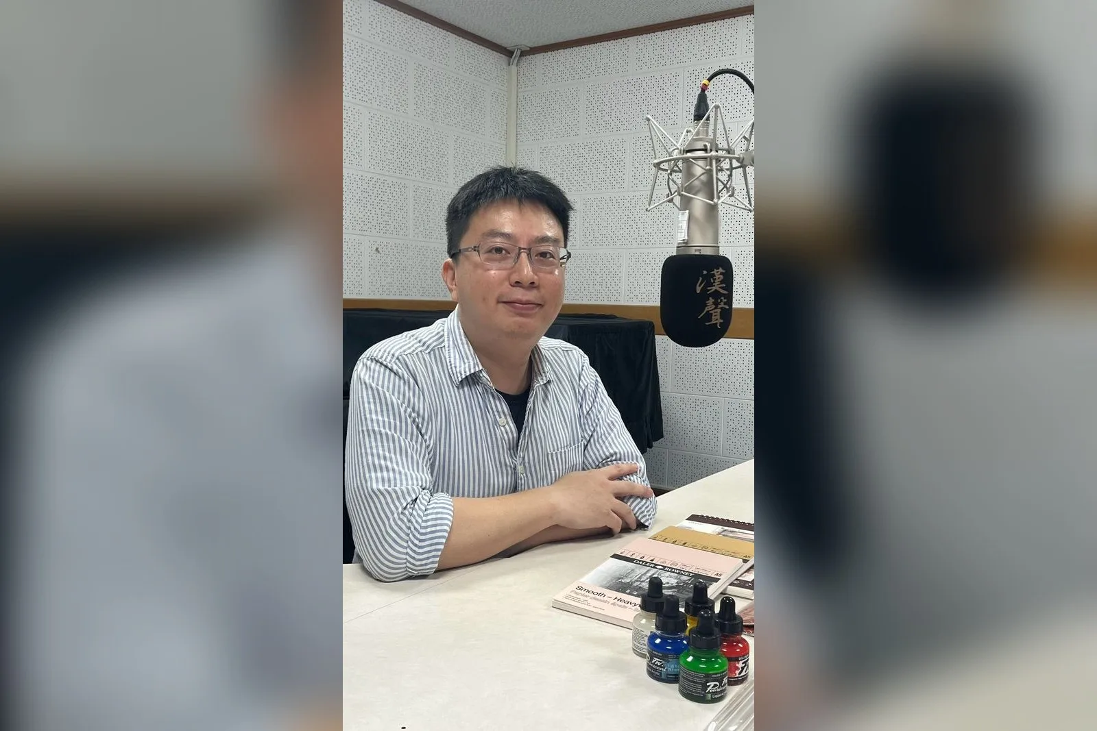 陳坤陽在錄音室受訪，桌上放著畫紙與彩色墨水