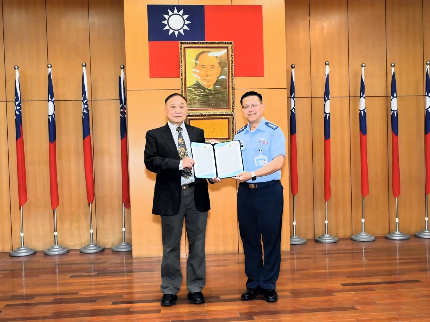 國際醫療減碳協會葉蔭民理事長（左）頒發永續報告書查證聲明書，由國軍高雄總醫院李柏群副院長（右）代表受領。