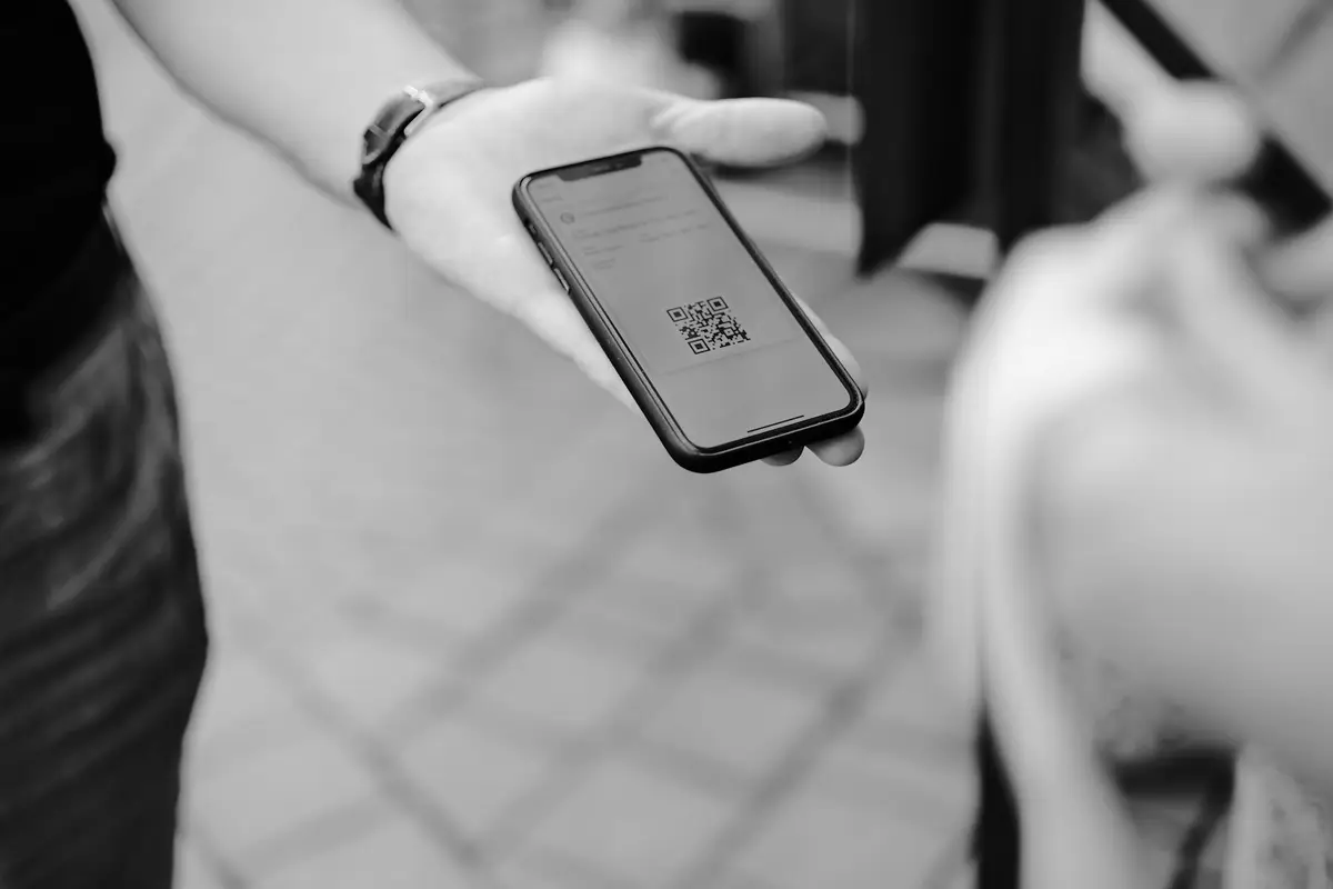 小店結帳櫃台前用手機掃描 QR Code 付款的情境