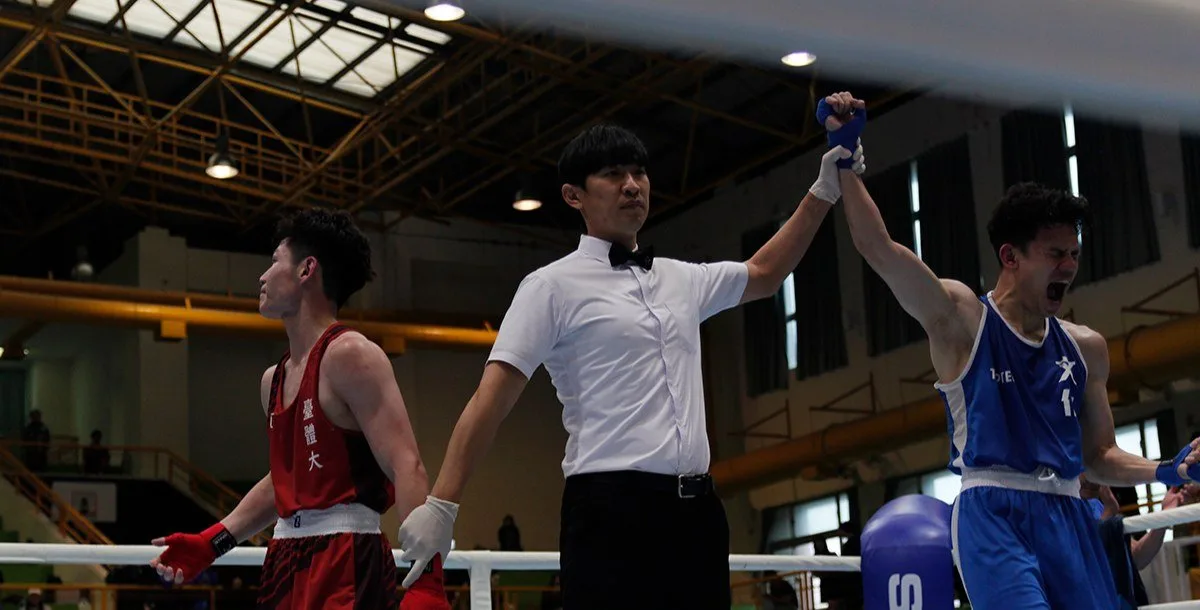 文化大學男子拳擊隊選手與教練在115年全大運拳擊賽場旁合影