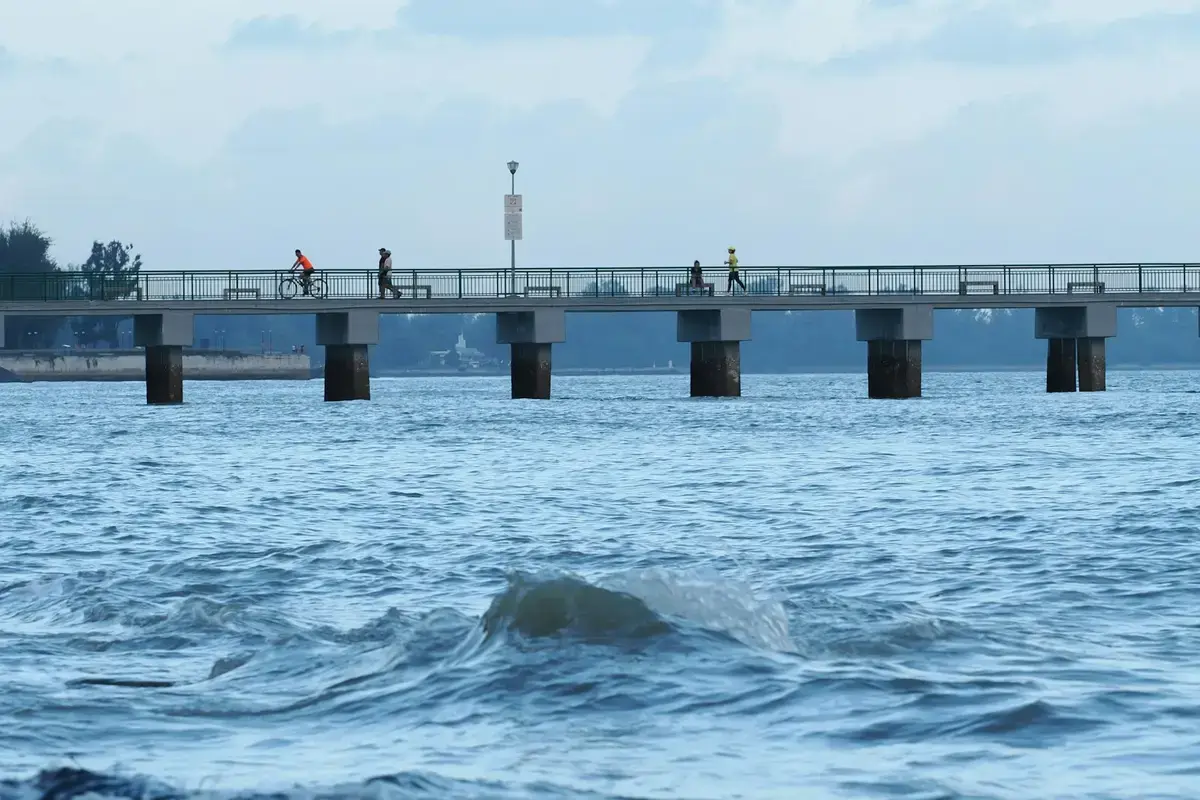 行人與單車騎士走過海面上的長橋