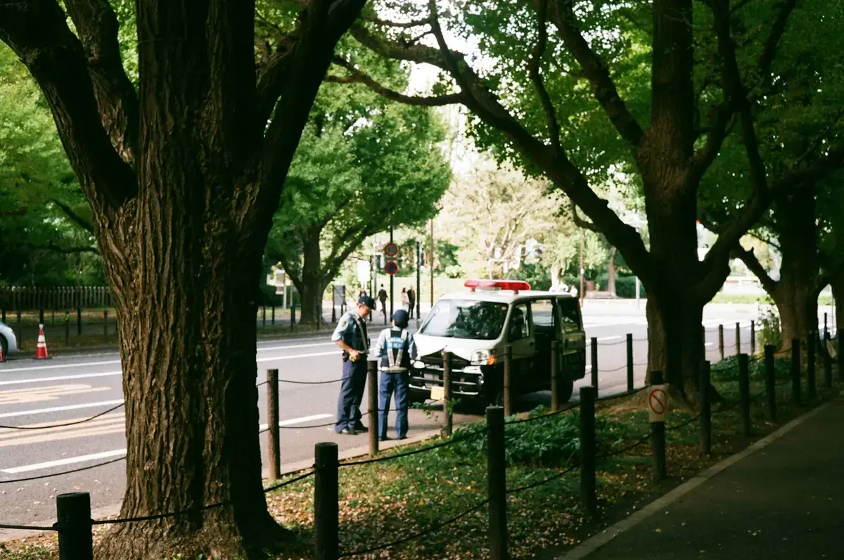 公園旁兩名員警在警車旁交談，作為警方協助民眾的示意照（示意圖）