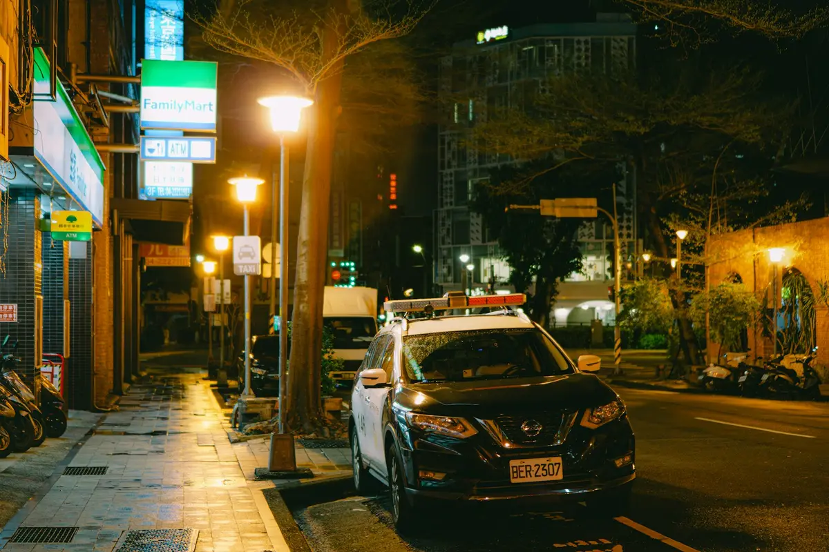 道路旁警車與城市街景，警民互助安全處置情境示意圖