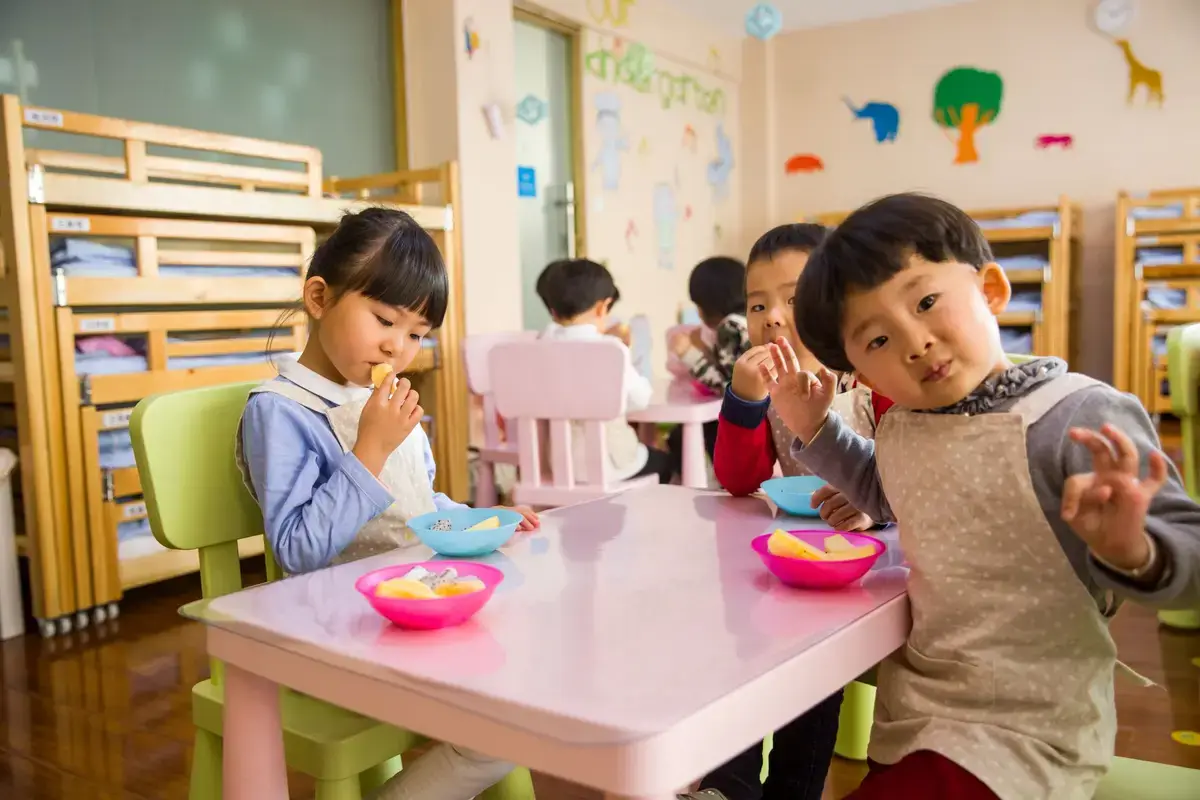 幼兒在教室餐桌用餐的校園午餐情境