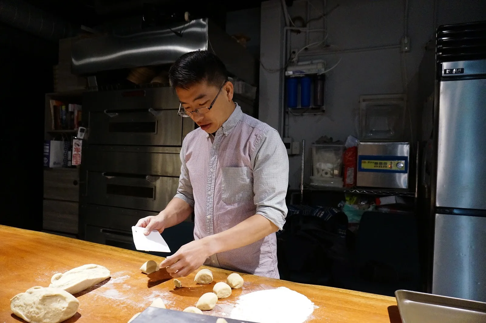 許雋詳在烘焙工作檯上分割麵團