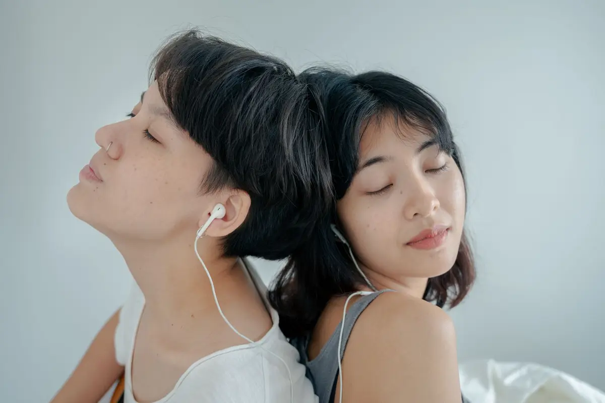 在家共用耳機聽音樂的兩個人