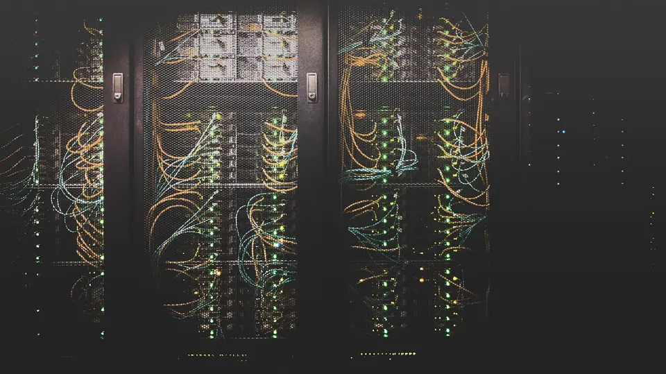 資料中心內排列的黑色伺服器機櫃，機櫃上方安裝電源配線與冷卻管線