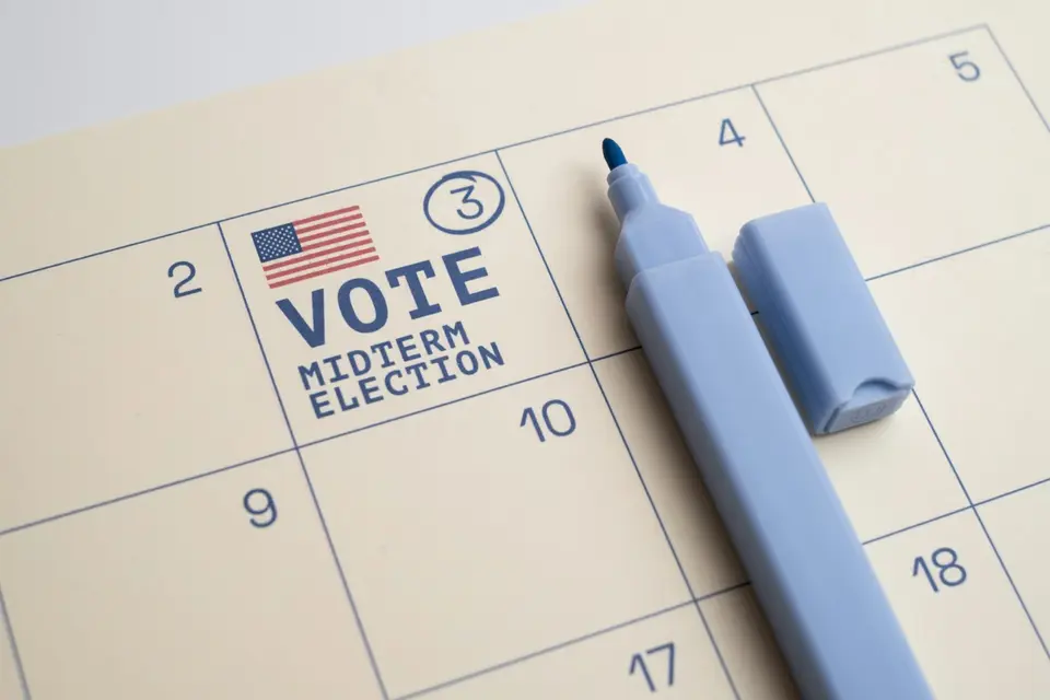 投票所內,一隻手在紙本選票上填寫選項
