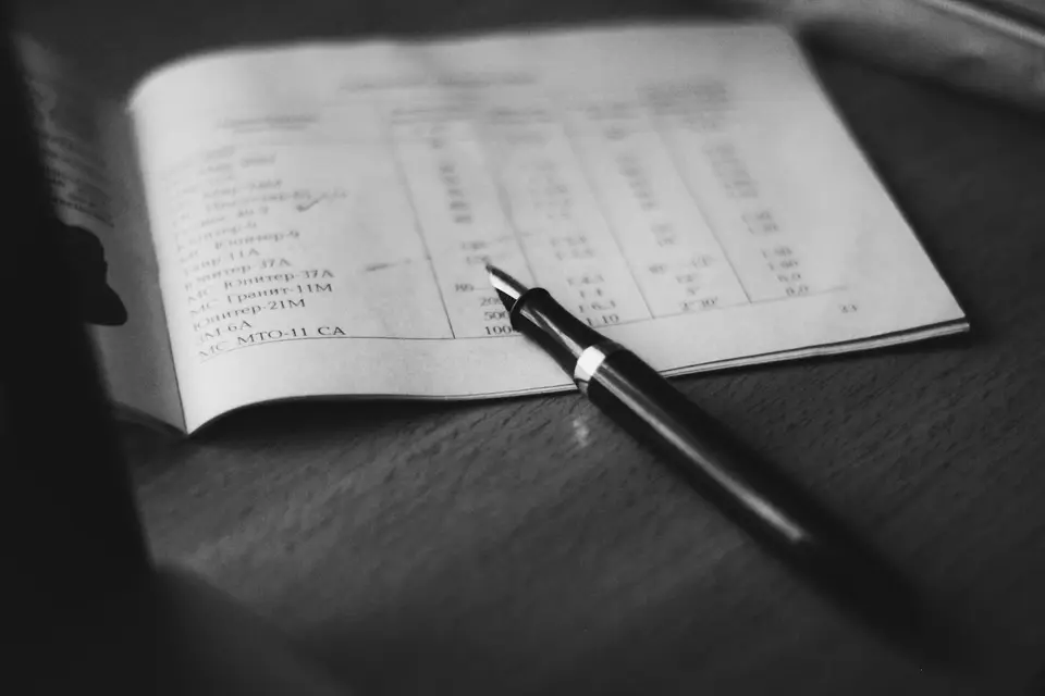 筆記本、股票報告與筆放在桌上，象徵投資人整理交易紀錄與風險檢查項目