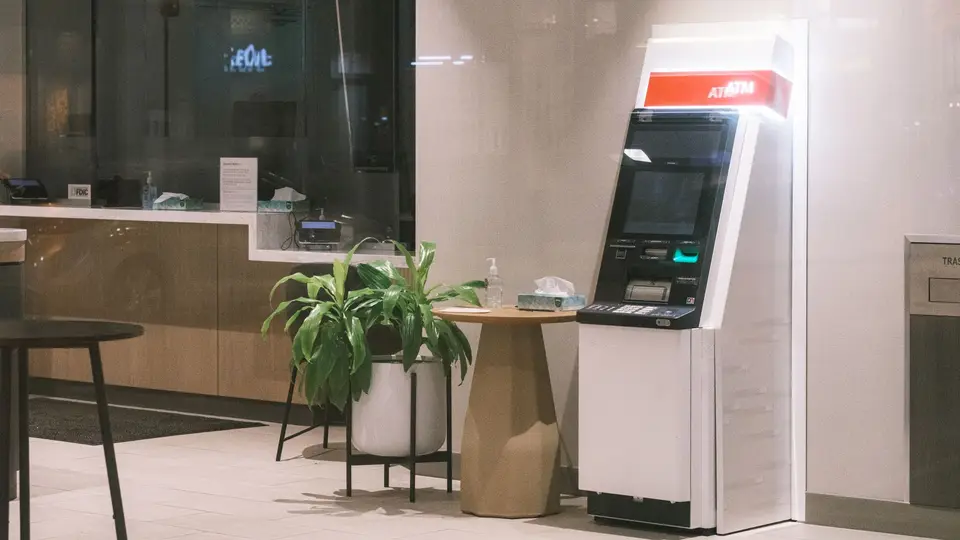 銀行營業廳的服務櫃檯，員工正在協助顧客辦理業務