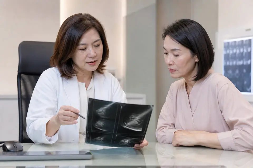 看待胸部大小時,先把乳房組織與胸壁肌肉分開理解(示意圖) 醫師與女性討論乳房影像檢查結果