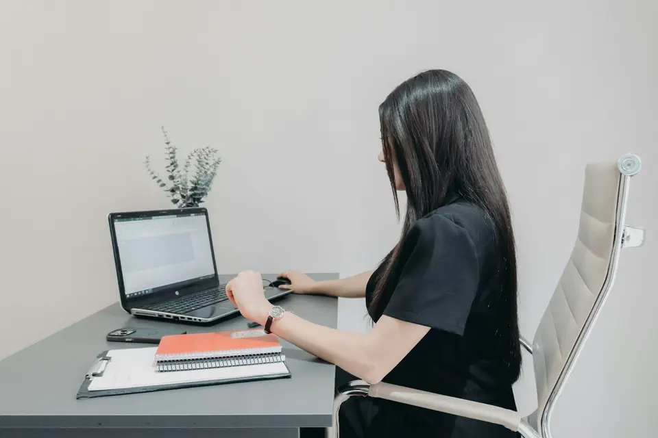 辦公桌前整理筆電與文件，象徵讀者依序核對工會公告與勞資程序資料