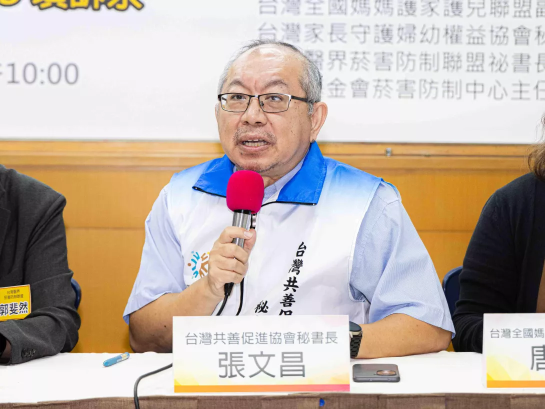 張文昌在座談中持麥克風發言,討論青少年與家庭支持