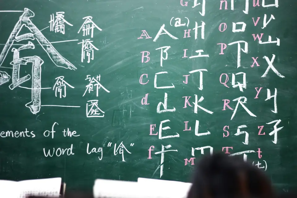 黑板上寫著中英文與漢字，象徵教學現場