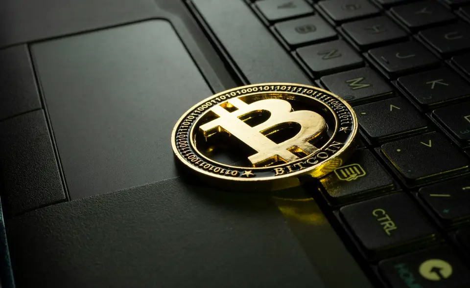 金色比特幣造型硬幣放在黑色電腦鍵盤上