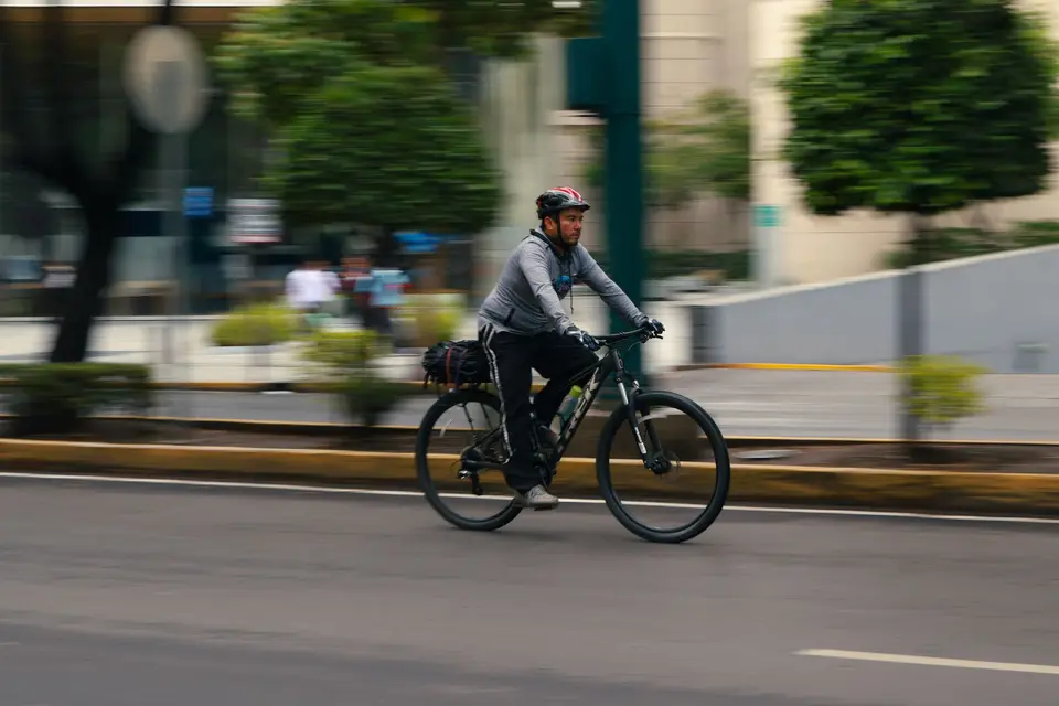騎士騎自行車穿過城市道路的通勤示意場景