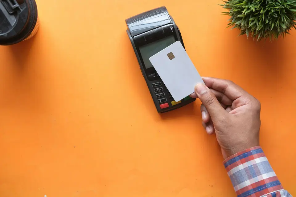 收銀台旁的感應式刷卡機，象徵 Apple Pay 感應付款前確認卡別與限制（示意圖）
