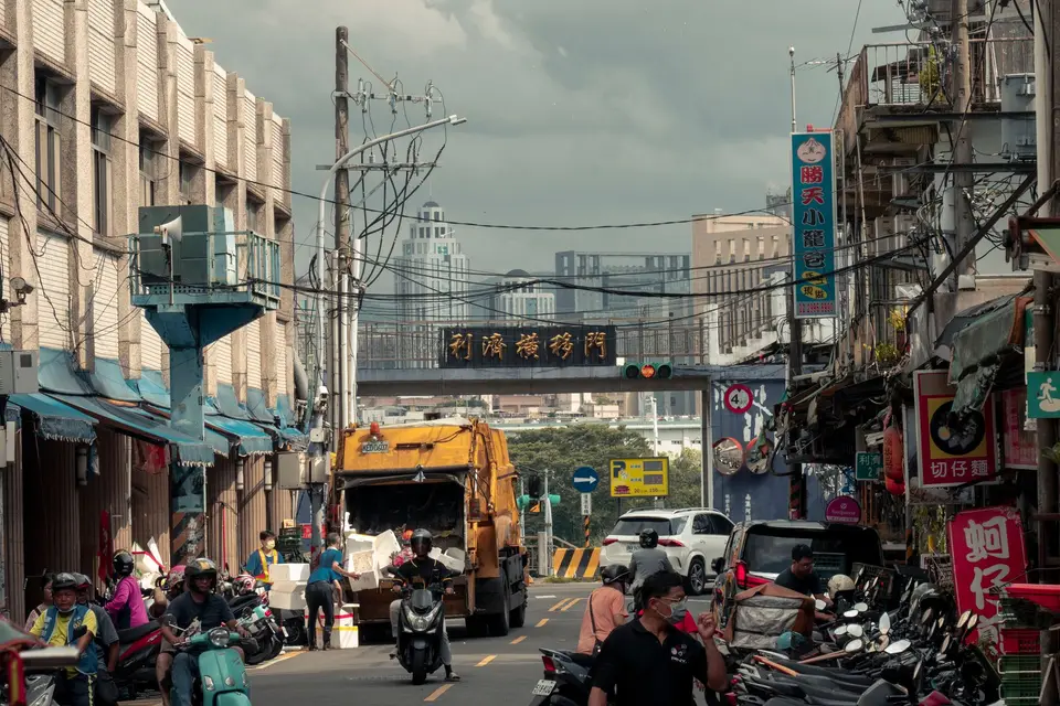 城市住宅街道上的垃圾車與等候倒垃圾的生活場景