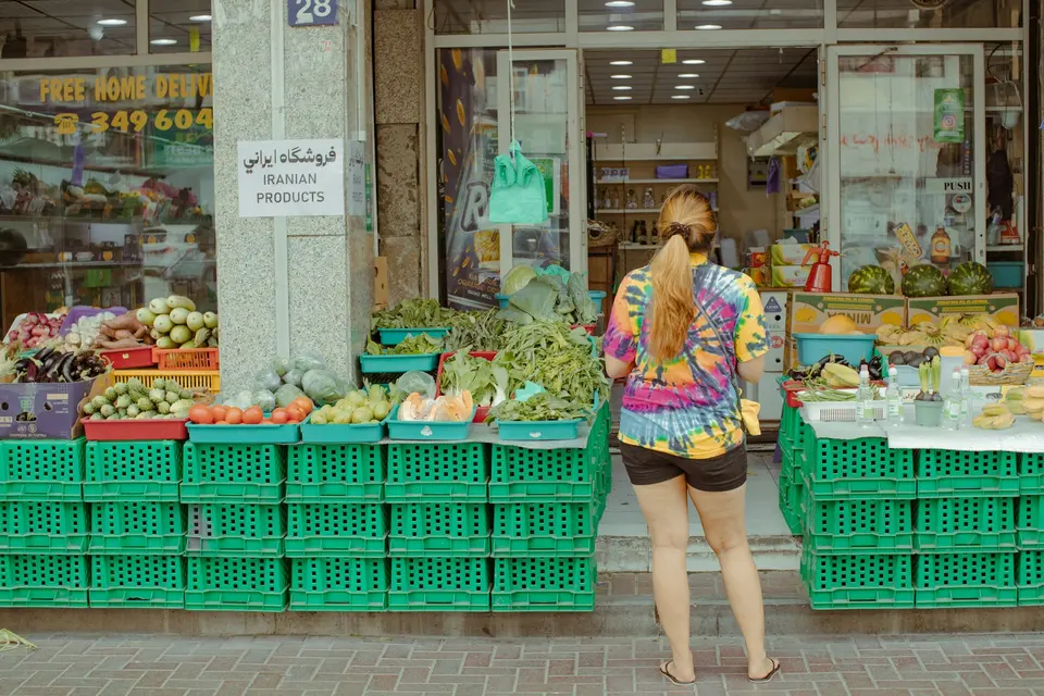 女性在蔬菜水果攤前挑選新鮮食材