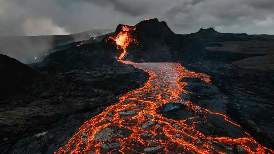 阿納克・喀拉喀托火山日前仍在活動,影響當地航班與海上活動安全(示意圖) 海上的活火山山頂冒出白煙,山體呈黑色,周圍是蔚藍海水