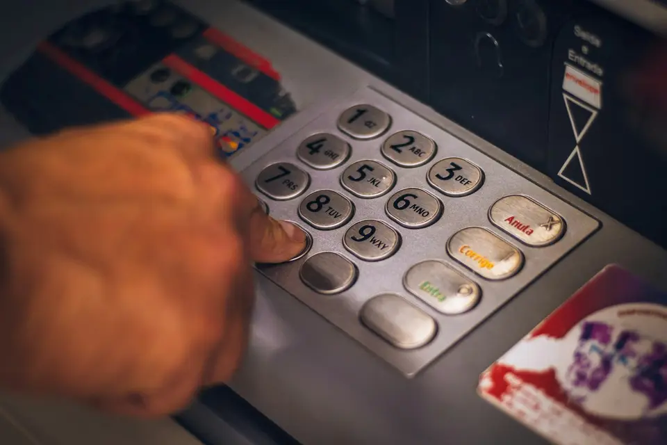 民眾從 ATM 取出鈔票的手部近景