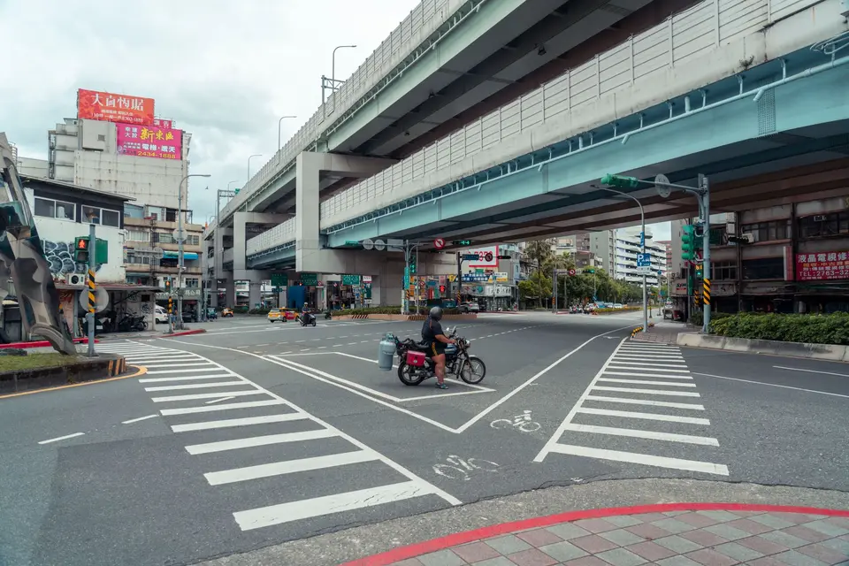 城市路口可見白色車道標線與轉彎動線,車輛依路型通過