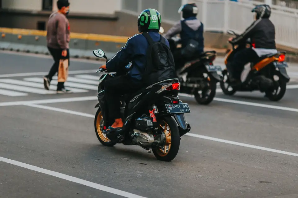 多名騎士在城市路口等候通行，呈現機車通勤場景