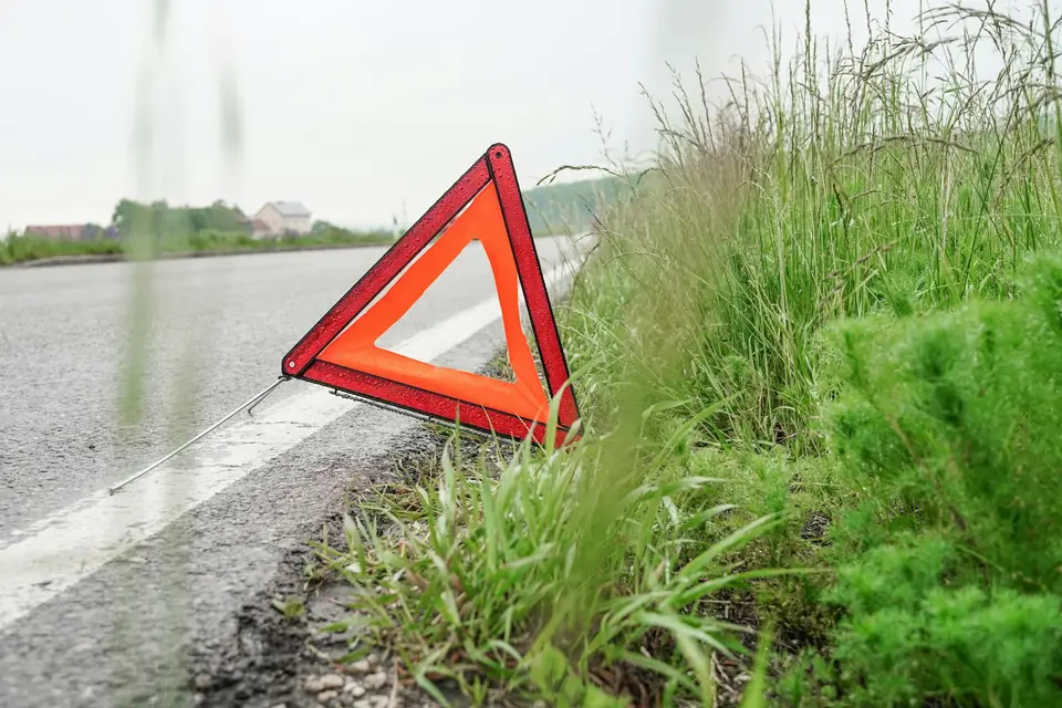 道路旁的警示三角架與車道，呈現記錄現場路況後提出反映的情境