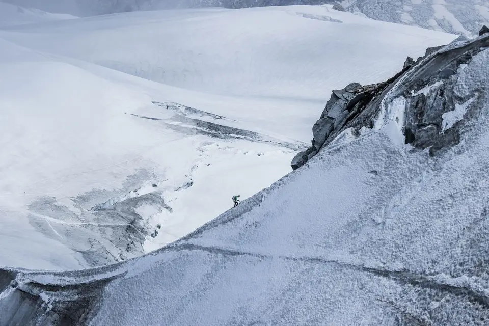 高海拔雪地登山隊伍在山坡上行進(示意圖)
