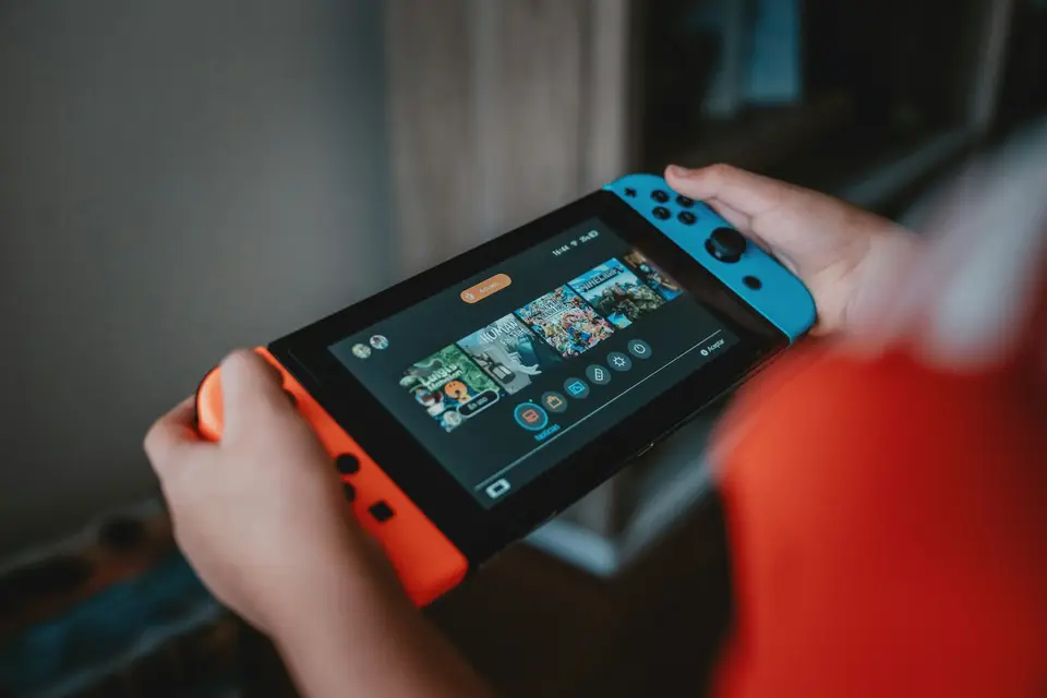 Nintendo Switch Online家庭方案比較遊戲服務與擴充包內容,遊戲控制器放在主機旁(示意圖)