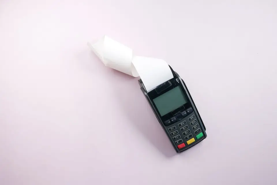 商店櫃檯上的刷卡機與列印出的交易簽單
