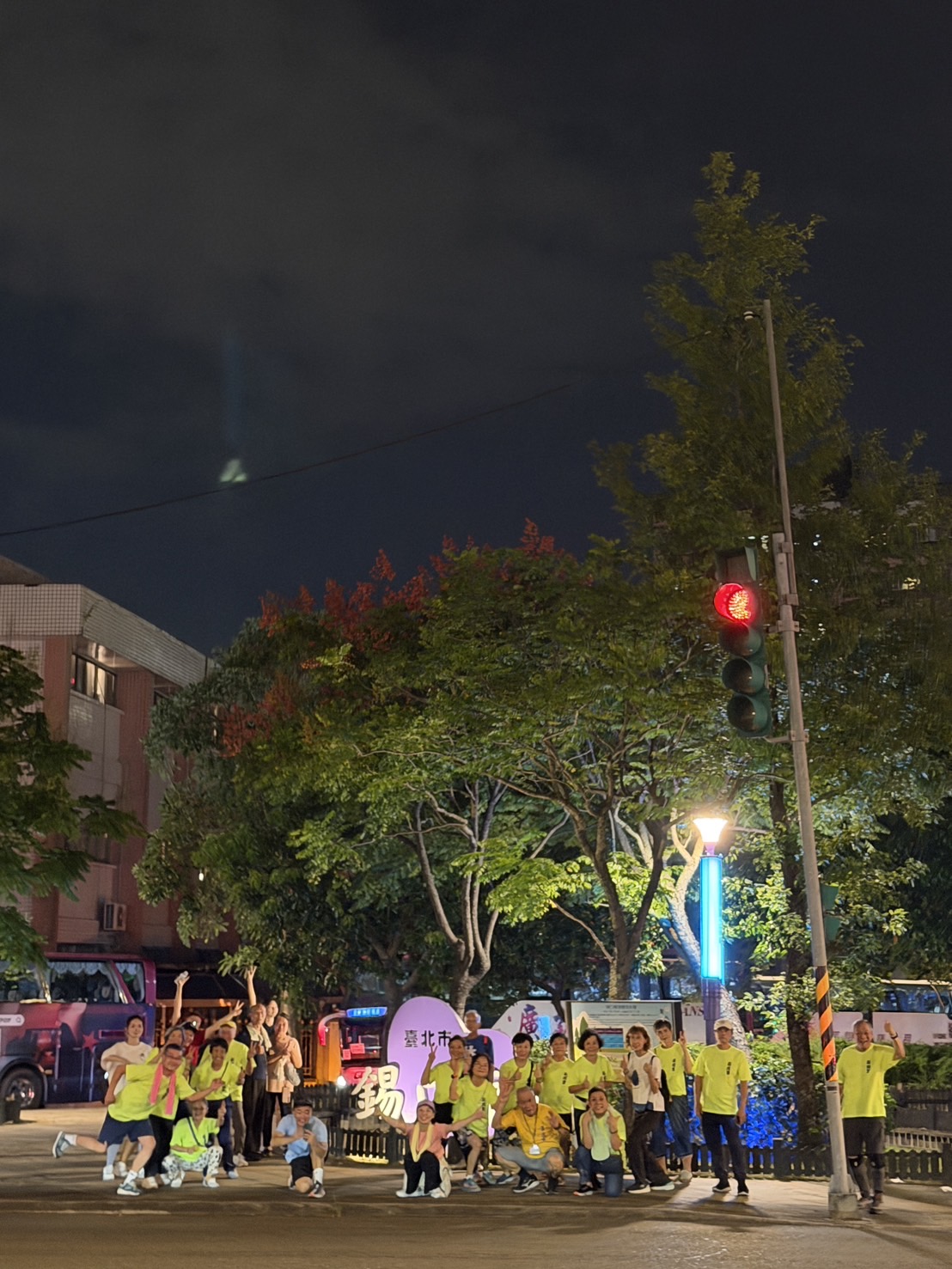 跑團與居民在夜間街區地標旁合影