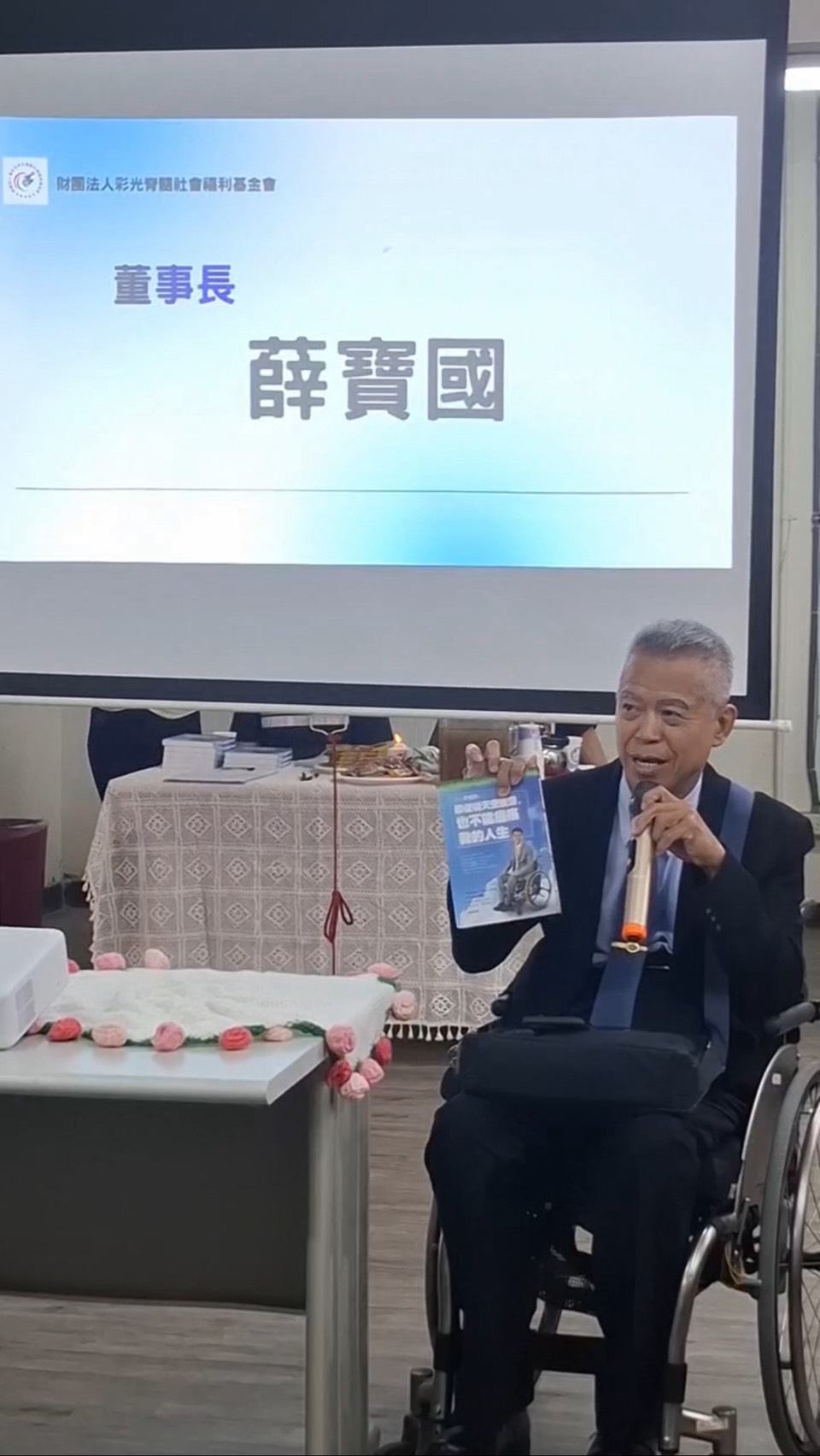 彩光脊髓社會福利基金會董事長薛寶國在活動中分享,投影畫面呈現基金會名稱與講者身分
