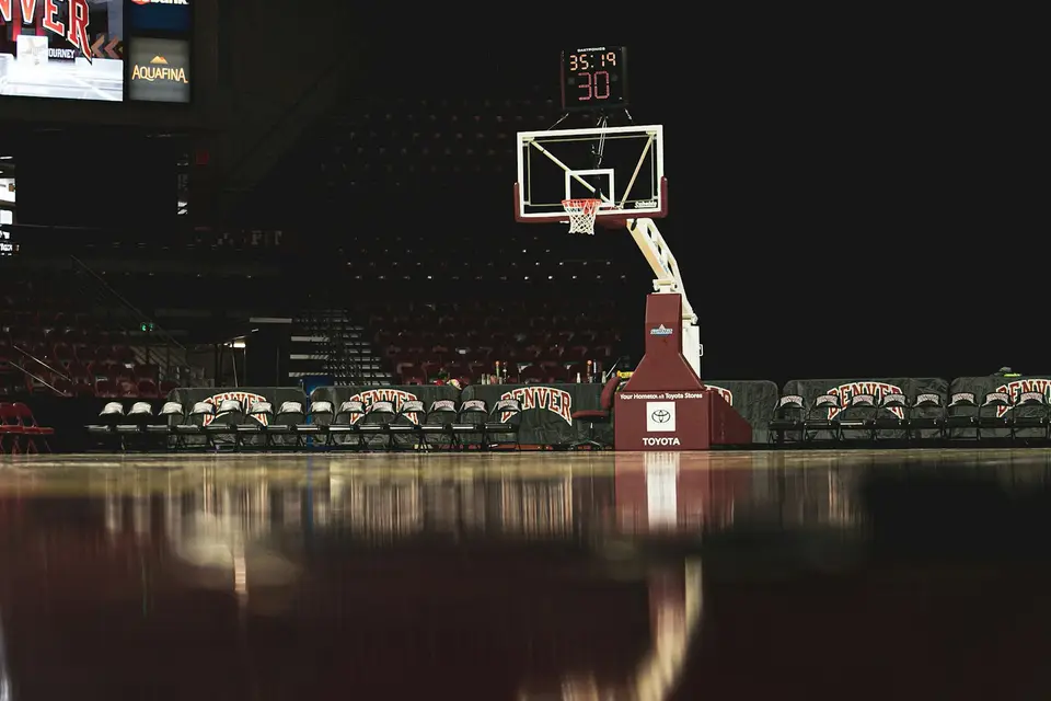 籃球場旁的電視轉播螢幕與球場燈光,呈現觀看 NBA 賽事的場景