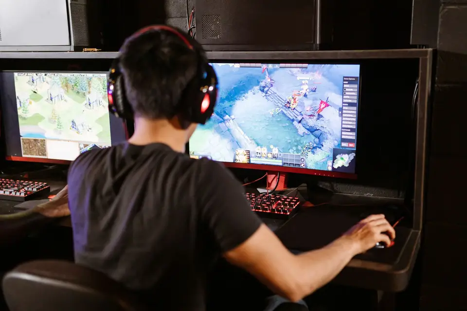 遊戲主機與筆電同時顯示遊戲畫面,呈現家庭成員各自使用遊戲裝置的情境