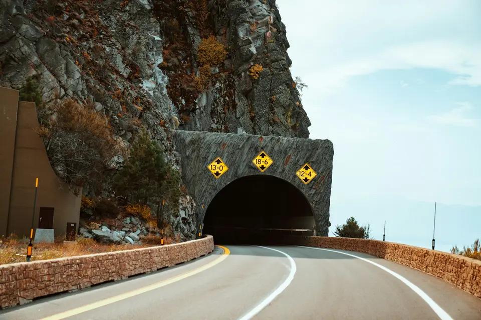 公路隧道洞口,一側是陡峭山壁(示意圖)