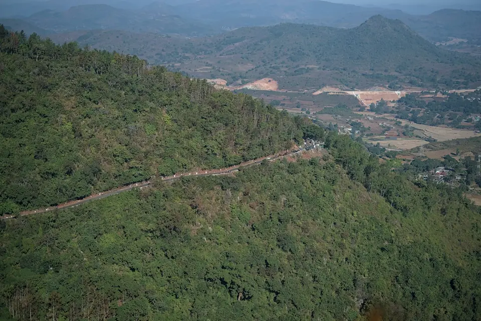 山區道路蜿蜒穿過林地與聚落，呈現長途駕駛會遇到的道路環境