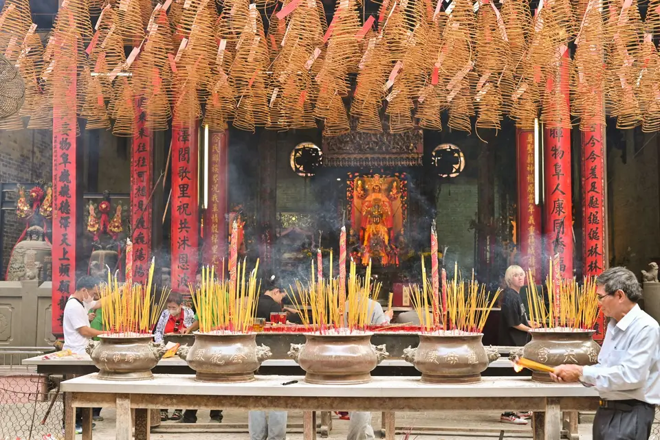 做十六歲儀式以向七娘媽祭拜為核心,感謝幼年至成人時期的庇佑(示意圖) 廟宇香案前擺滿香燭與供品,香煙裊裊升起。