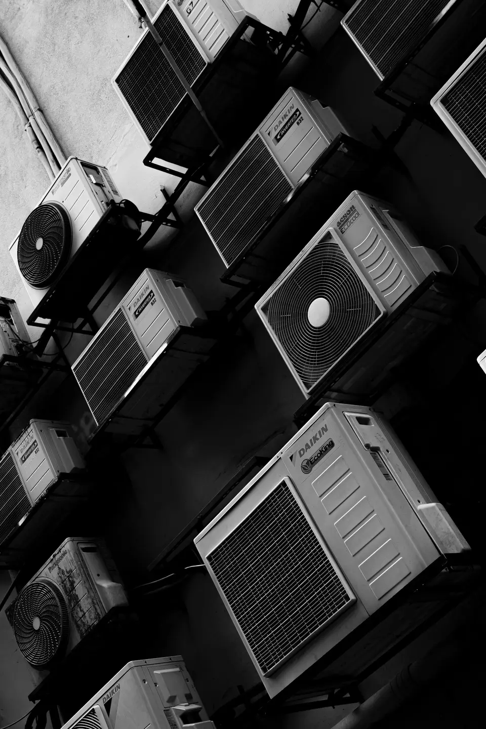集合住宅外牆排列多台室外冷氣機，呈現大樓用電設備情境
