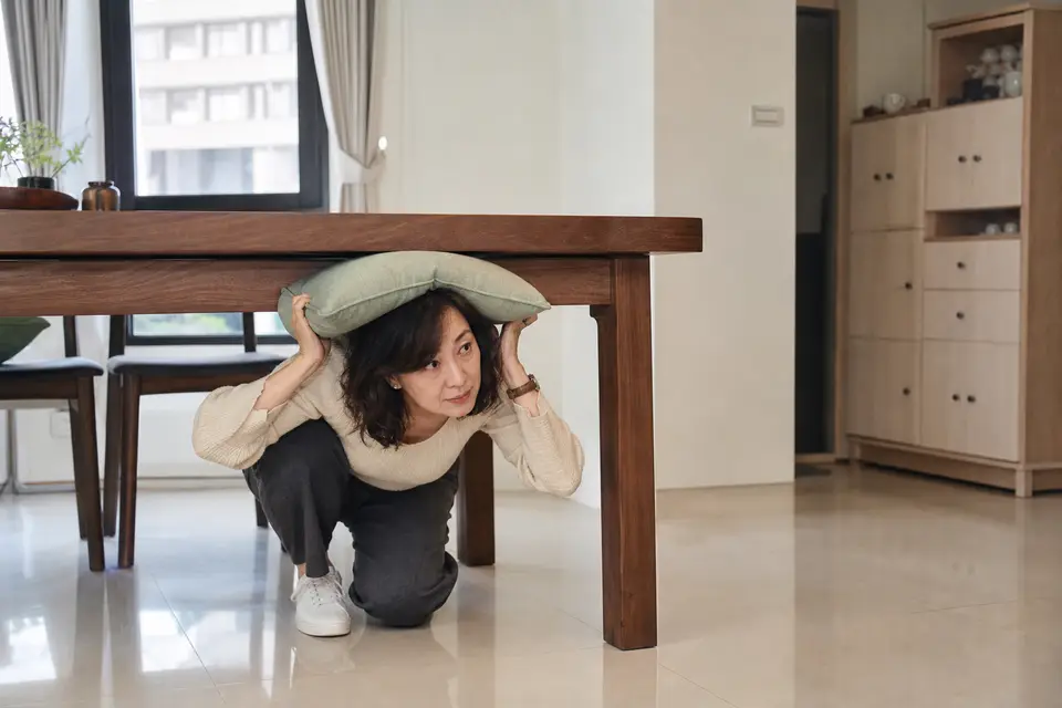 台灣住家客廳的堅固桌子與保護頭頸的墊子,窗戶與高櫃位在遠處。