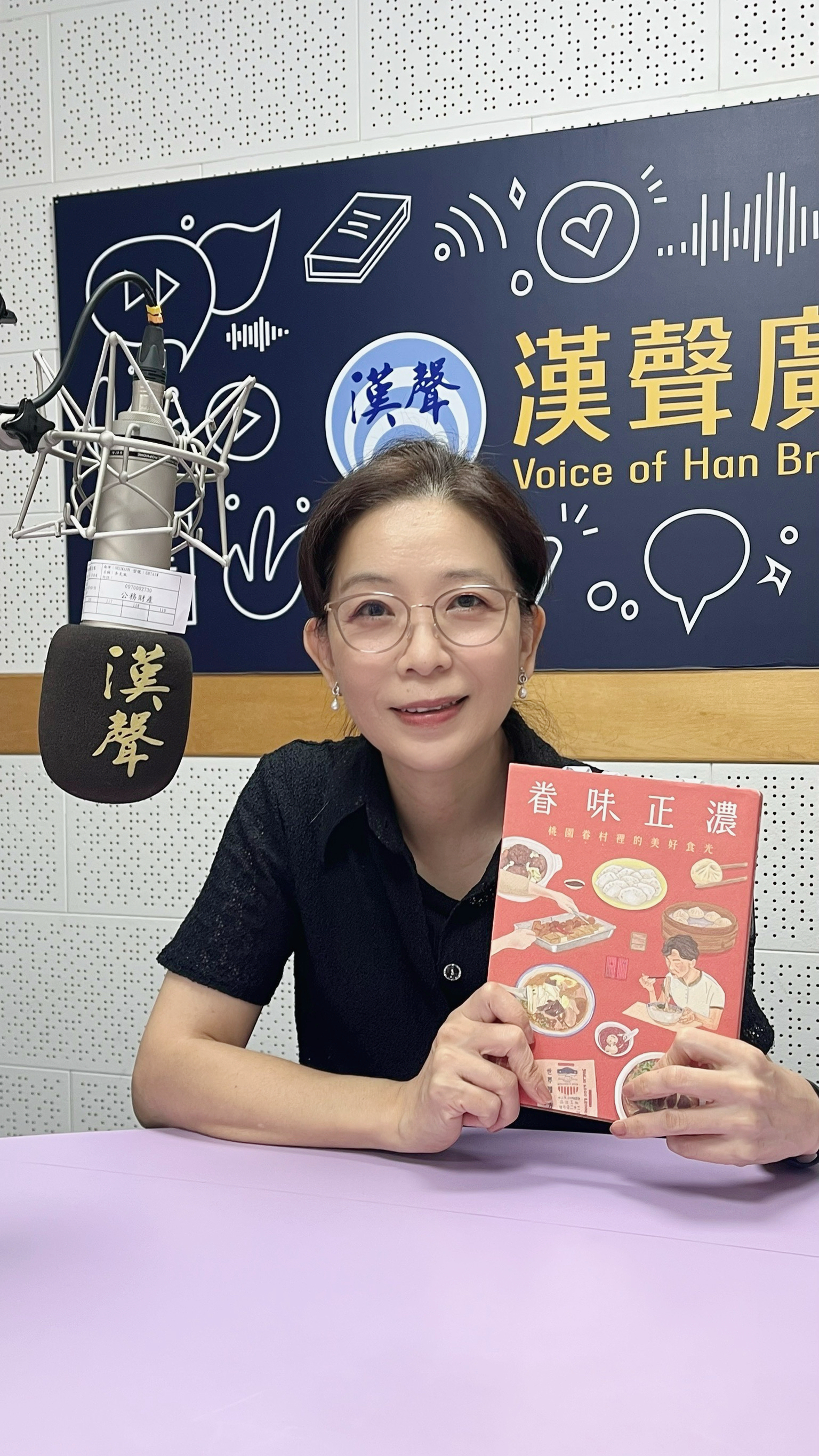 李絲絲手持《眷味正濃》在電台拍照