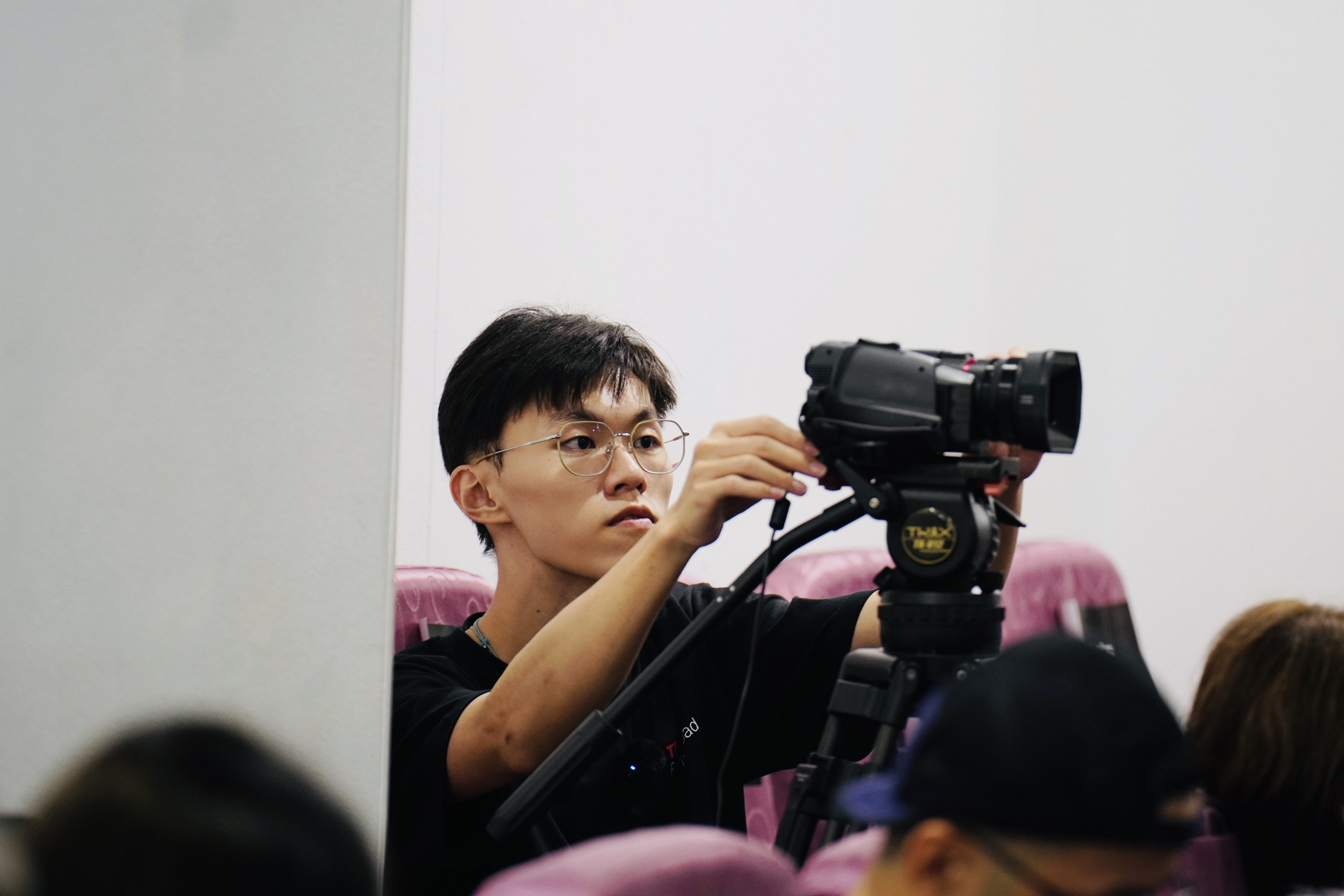 TEDxRenaiRoad志工在觀眾席使用攝影機記錄活動,呈現影像工作也是舞台的一部分