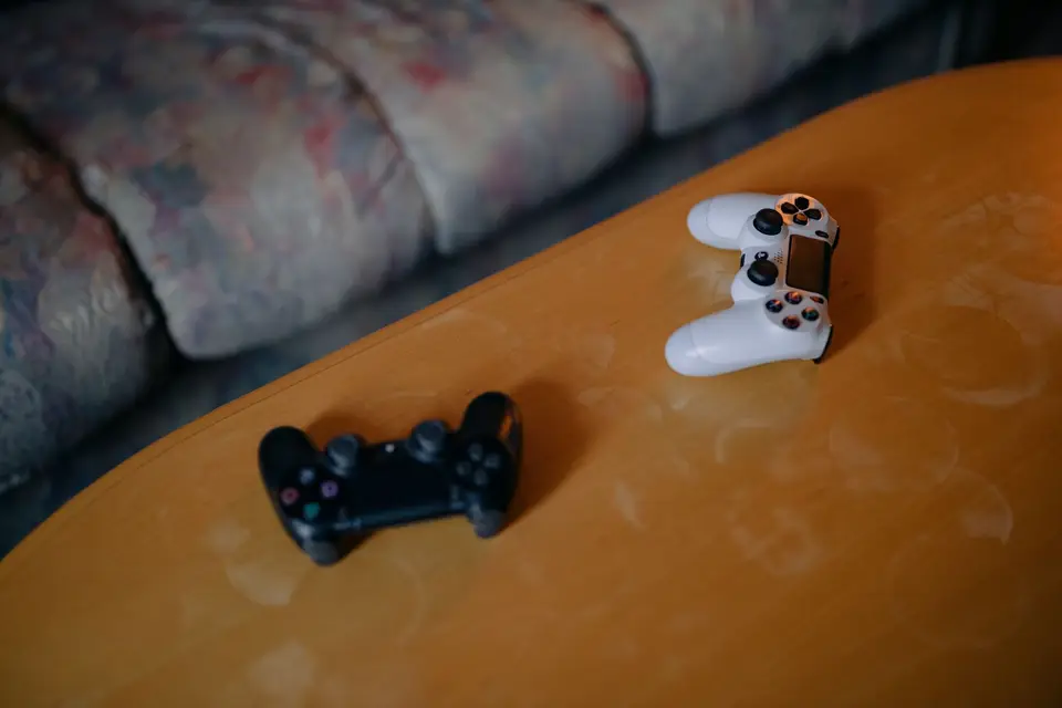 Xbox主機共享以同一台主要Xbox上的個人設定檔使用遊戲(示意圖) 客廳沙發旁的兩支遊戲手把