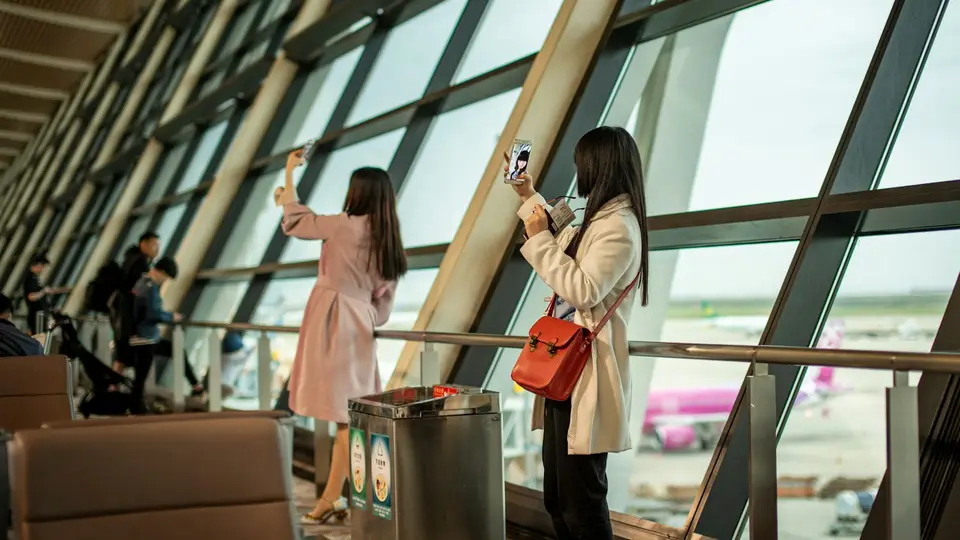 旅客在機場登機門使用手機